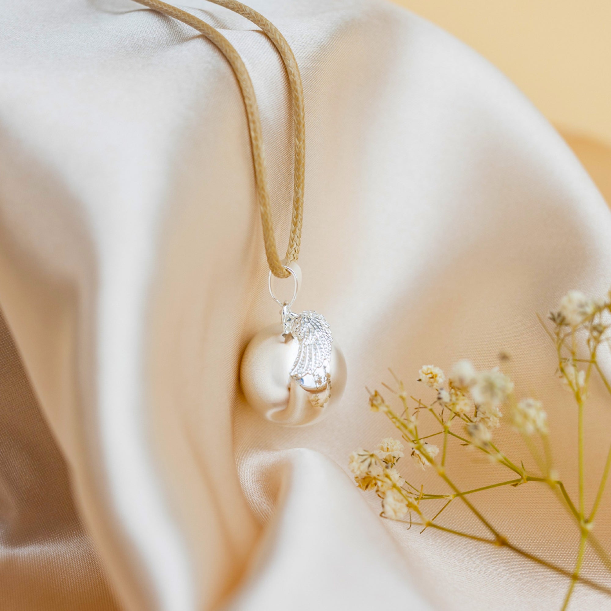 Stříbrná rolnička s motivem andělského křídla – detail povrchu